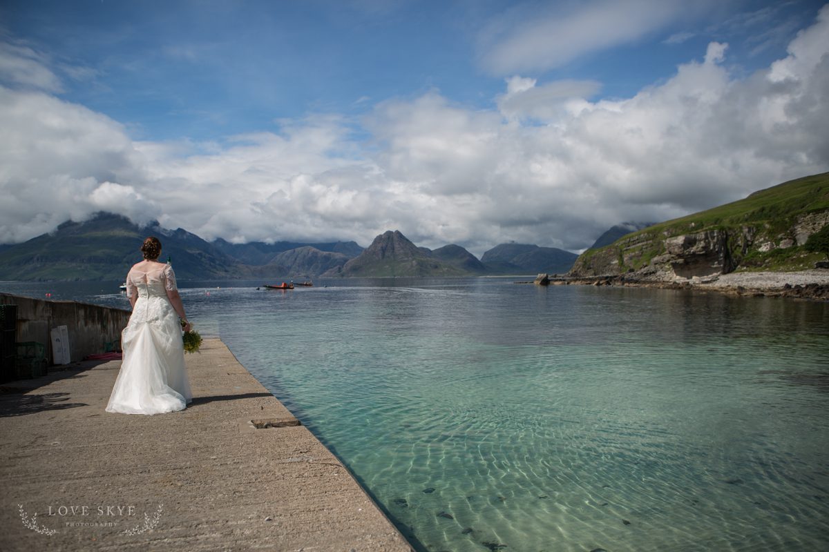elopement bride on pier with view to Cuillin mountains Isle of Skye