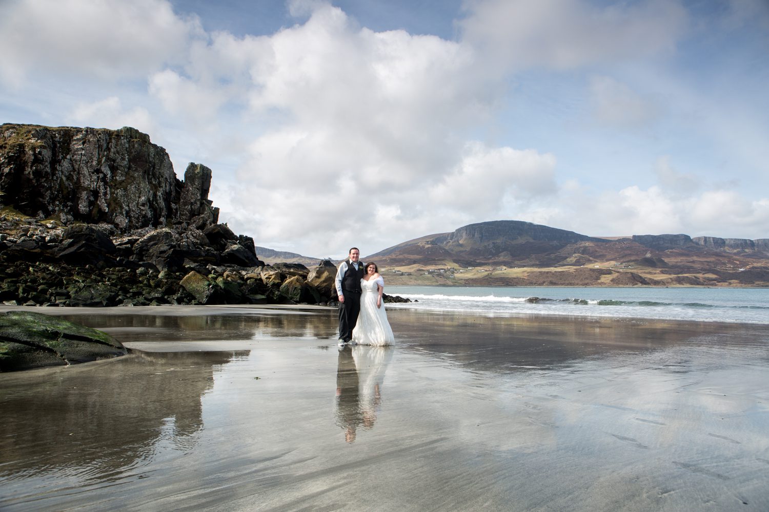 Bride and groom reflected at Staffin beach Isle of Skye at their elopement