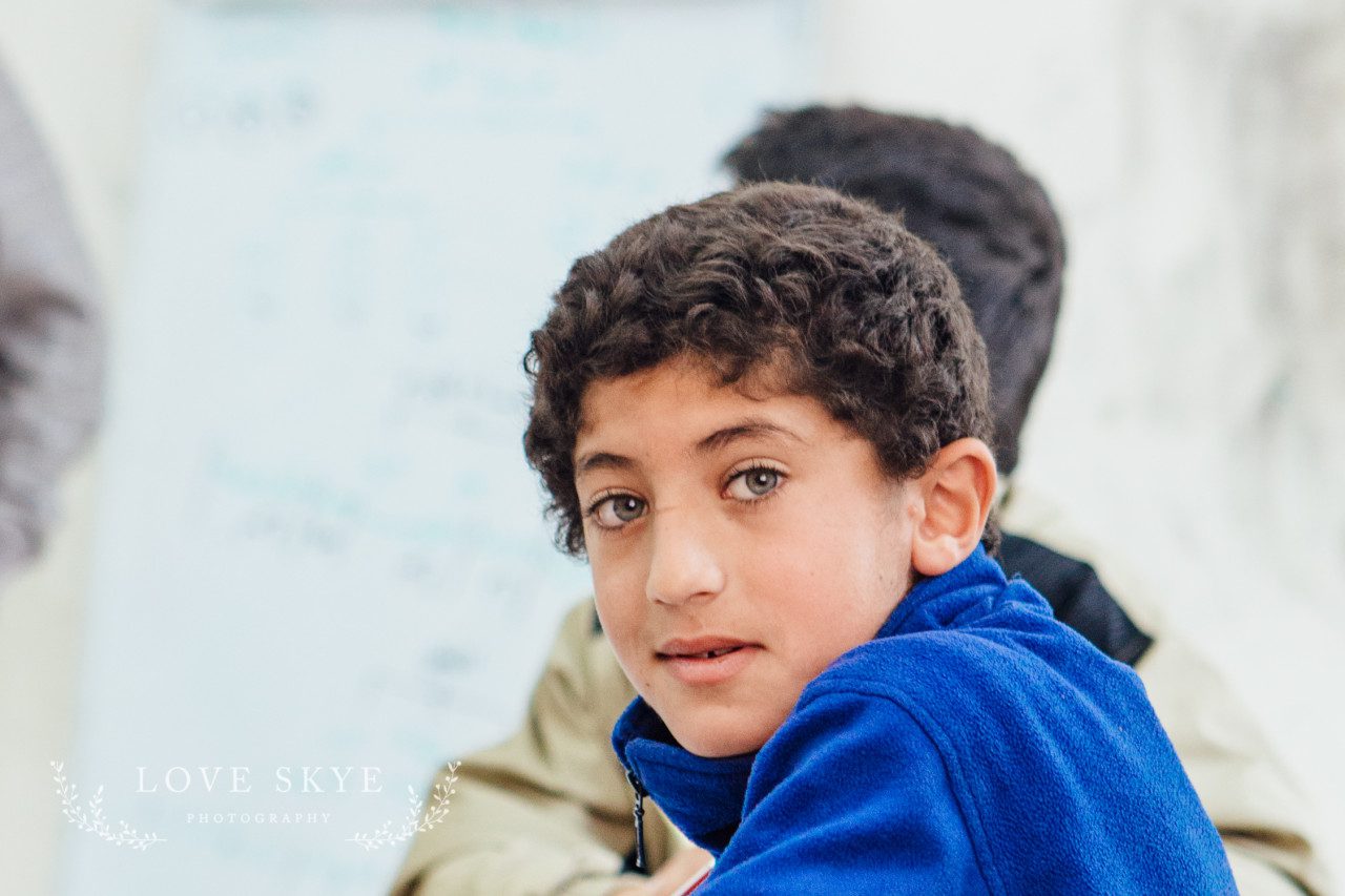 Syrian refugee child startling blue eyes in class room northern Jordan