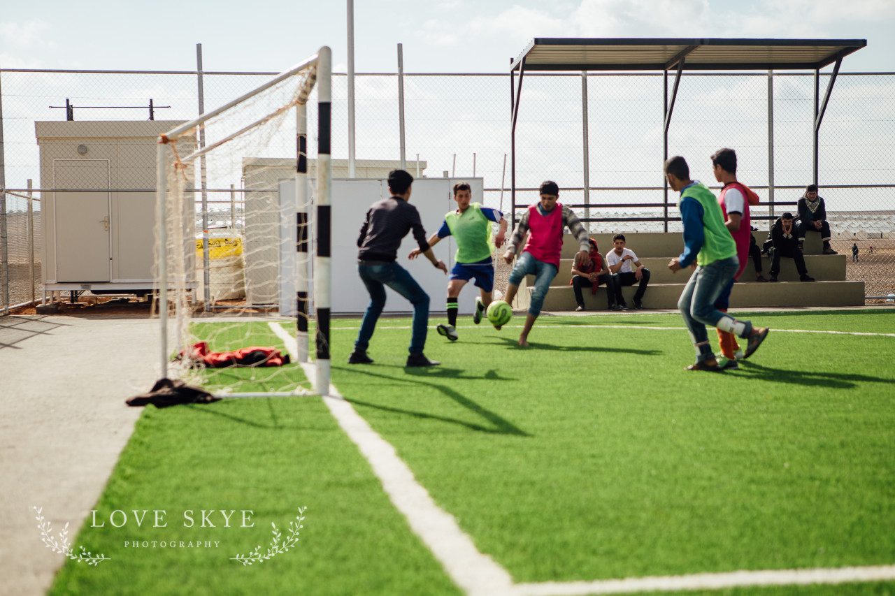 Teenage Syrian refugee boys play football at World Vision pitches Azraq Camp Jordan