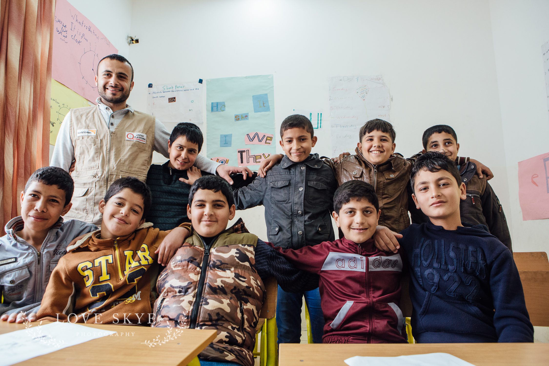 Class of Syrian refugee boys at remedial school in Jordan with World Vision project teacher