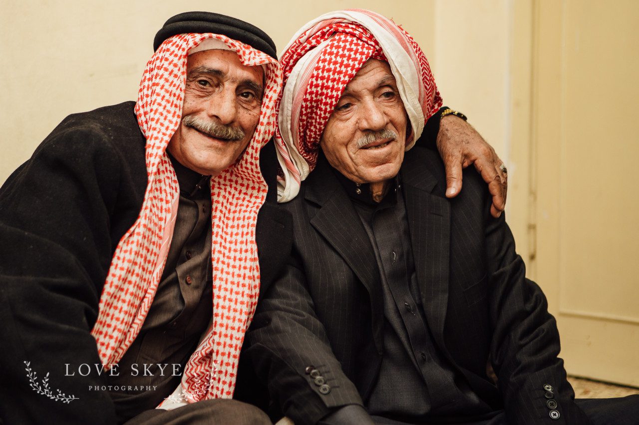 Elderly Syrian male refugees embrace while telling escape story Jordan