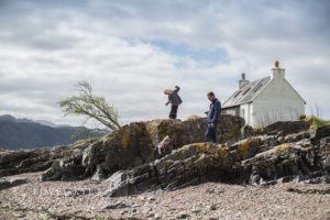 Isle of Skye family photographer family on beach with small white house in background