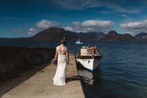 Bride walks down jetty to Misty Isle boat Cuillin in background