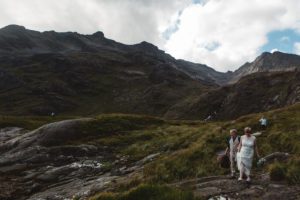 Bride and groom walk to ceremony among mountains loch coruisk