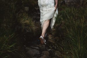 Bride and groom walk to ceremony among mountains loch coruisk