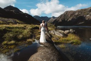 Bride and groom walk to ceremony among mountains loch coruisk