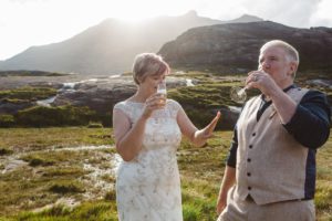 Bride sips champagne and looks at wedding ring Loch Coruisk