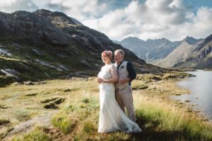 Bride and groom cuddling for photographs at Loch Coruisk