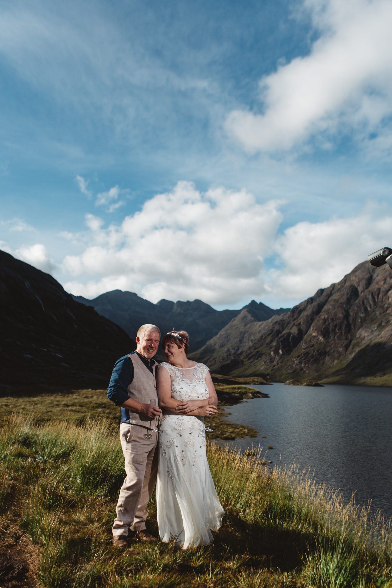 Bride and groom cuddling for photographs at Loch Coruisk