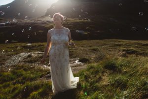 Backlit bride surrounded by bubbles at Loch Coruisk