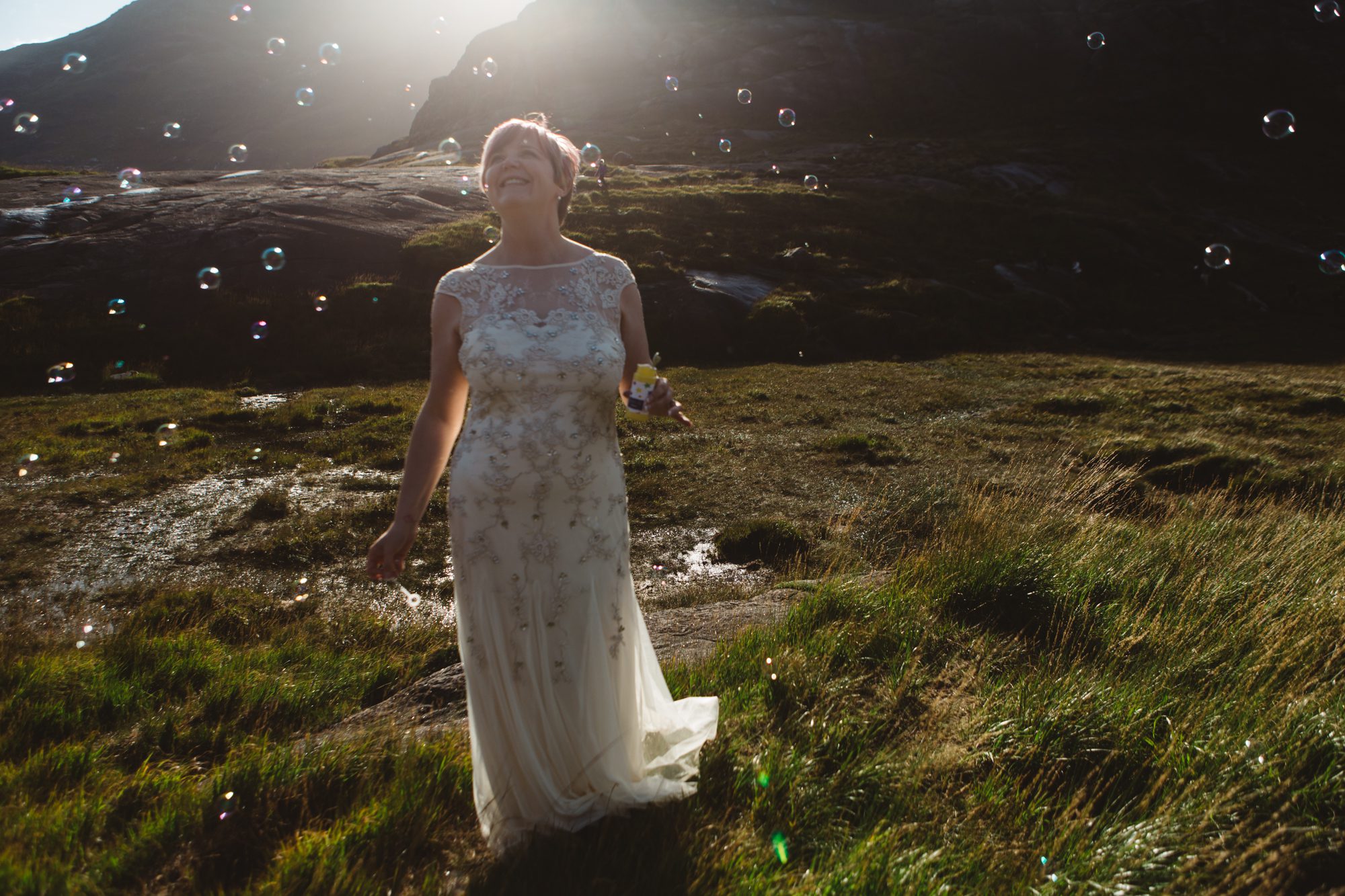 Backlit bride surrounded by bubbles at Loch Coruisk