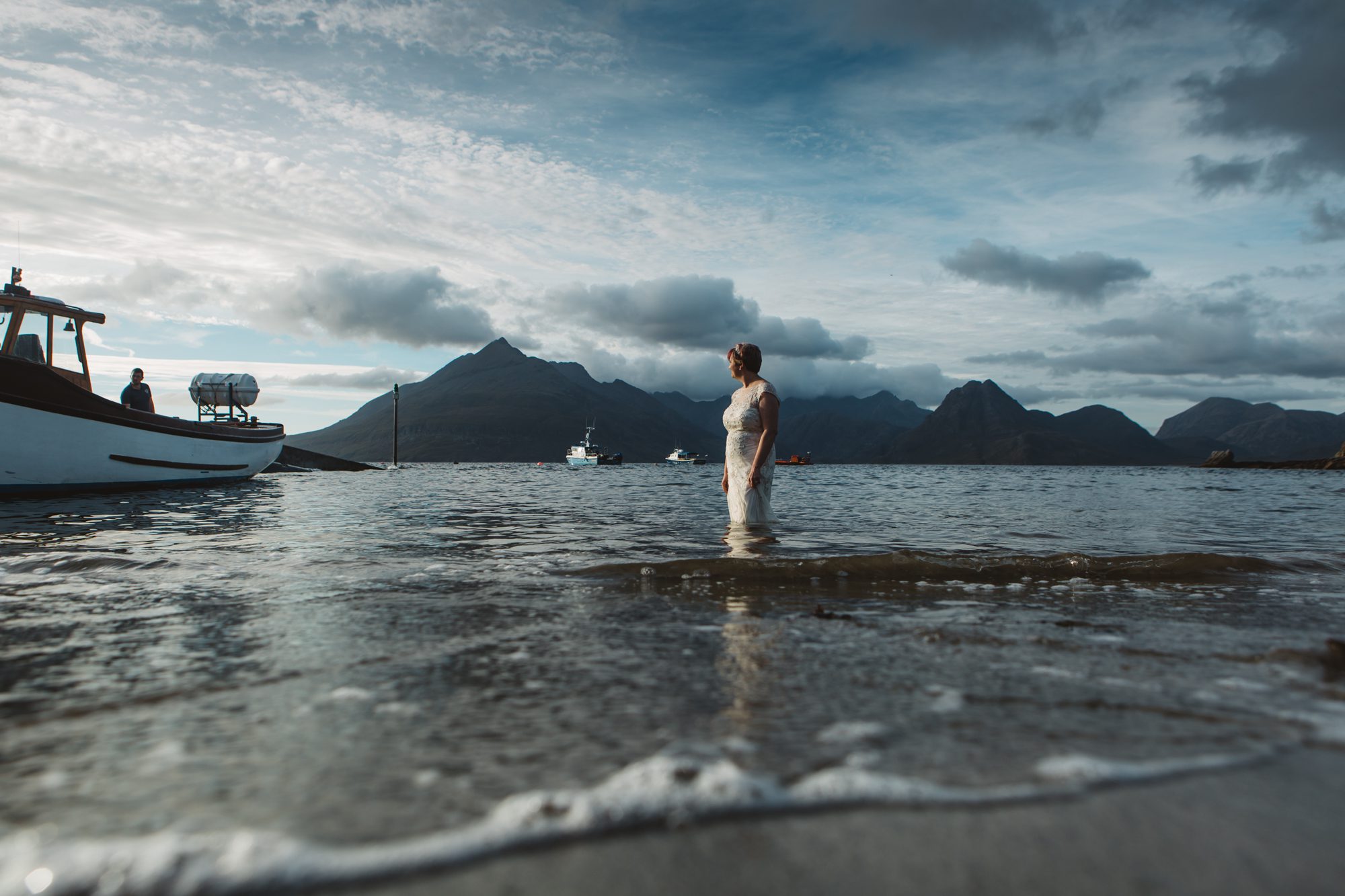 bride in wedding dress paddling in sea at Elgol Isle of Skye