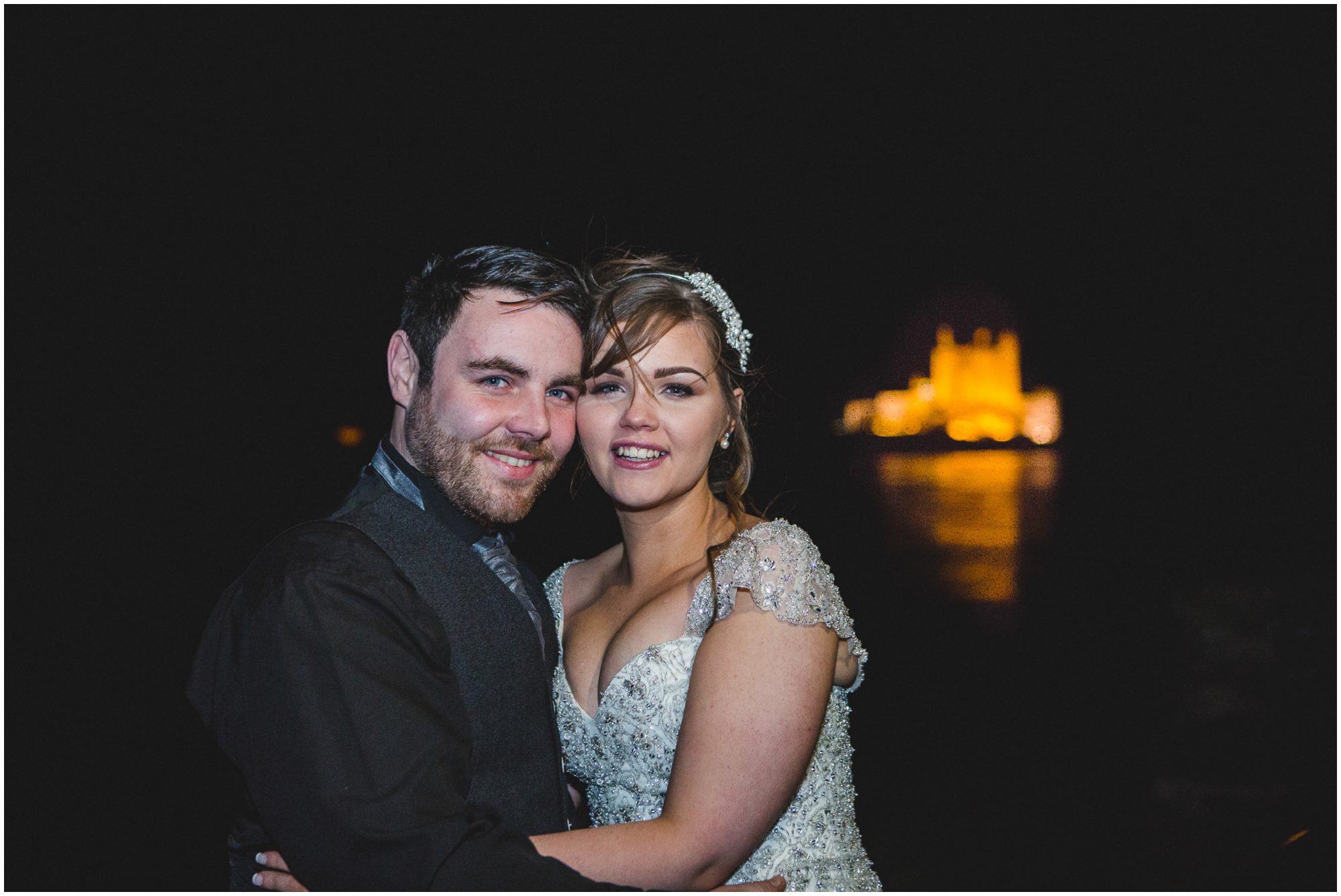 Bride and Groom at night with Eilean Donan Castle floodlight in background
