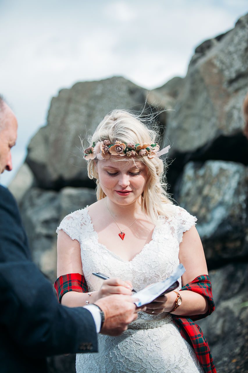 Bride signs register outside on Staffin beach Isle of Skye
