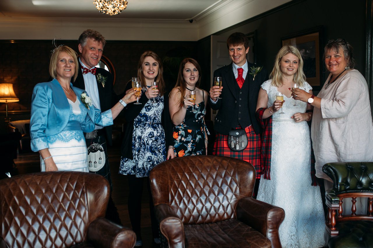 Wedding couple toasting with family at Flodigarry House Hotel Skye