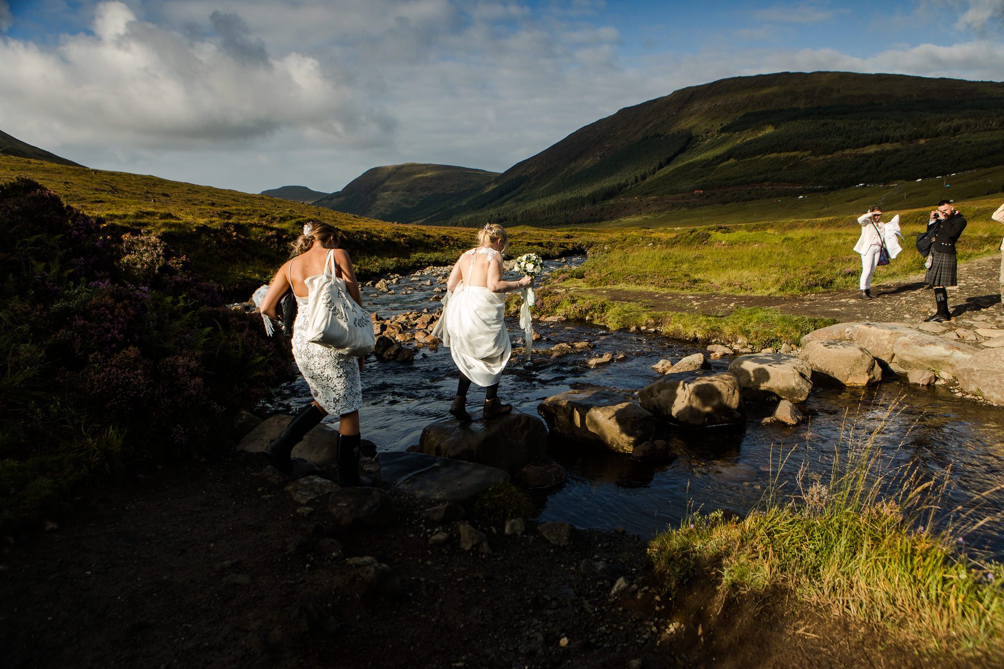 Bride crosses stepping stones Fairy Pools Isle of Skye