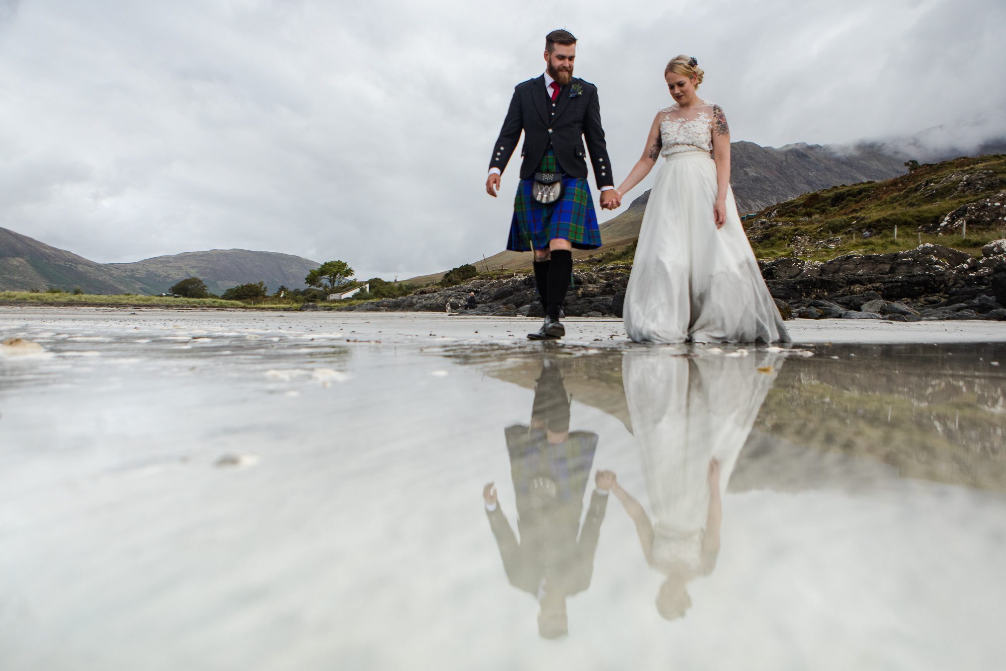 Bride and groom reflected on wet sands Glenbrittle beach Isle of Skye