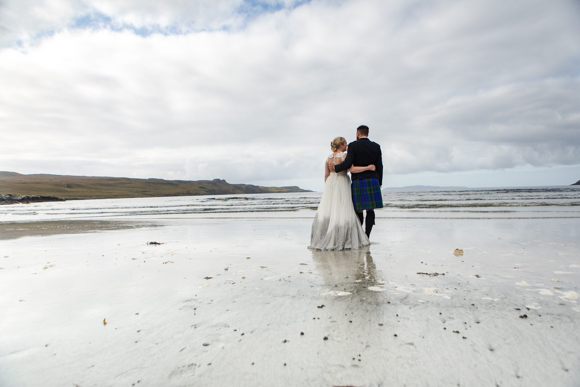 Bride and groom reflected in volcanic sands Glenbrittle Isle of Skye