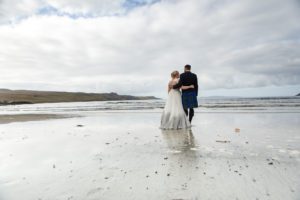 Bride and groom reflected on wet sands Glenbrittle beach Isle of Skye