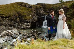 Bride and groom reflected in volcanic sands Glenbrittle Isle of Skye
