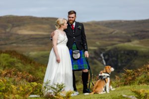 Bride and groom hiking with dogs Fairy Glen Isle of Skye Elopement