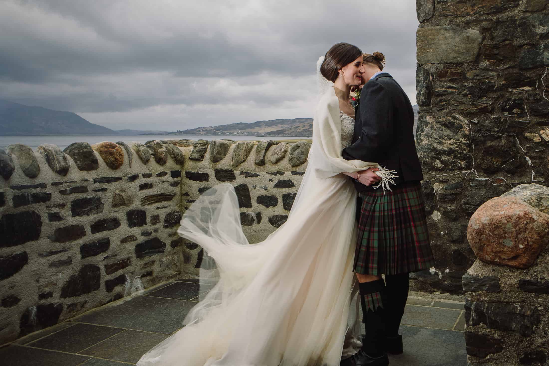 Bride and groom kiss courtyard Eilean Donan Castle wedding photography