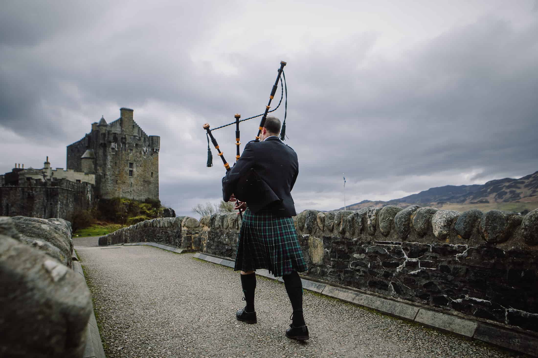 Piper leading bride to wedding bridge Eilean Donan Castle