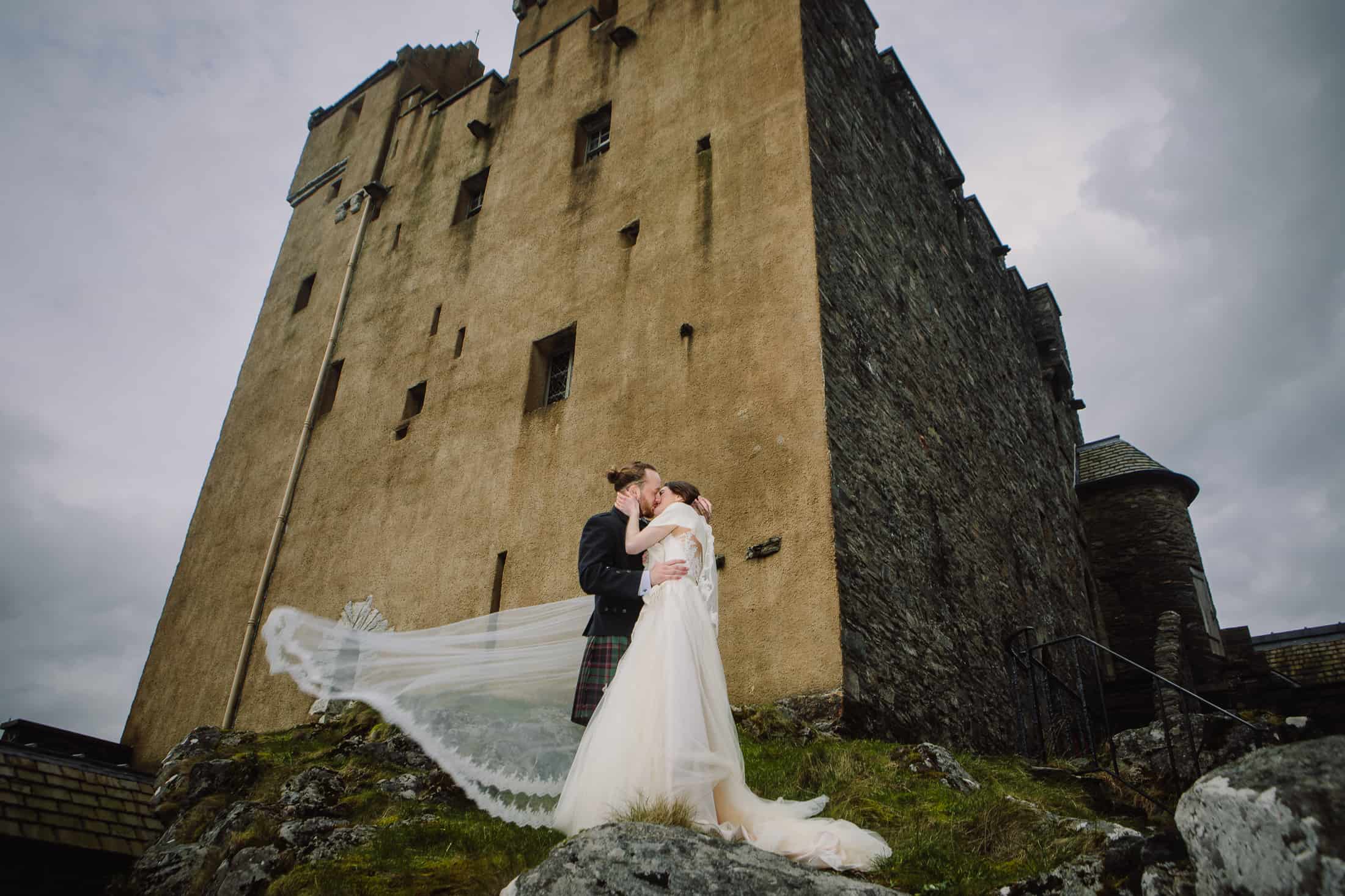 Bride and groom kiss courtyard Eilean Donan Castle wedding photography
