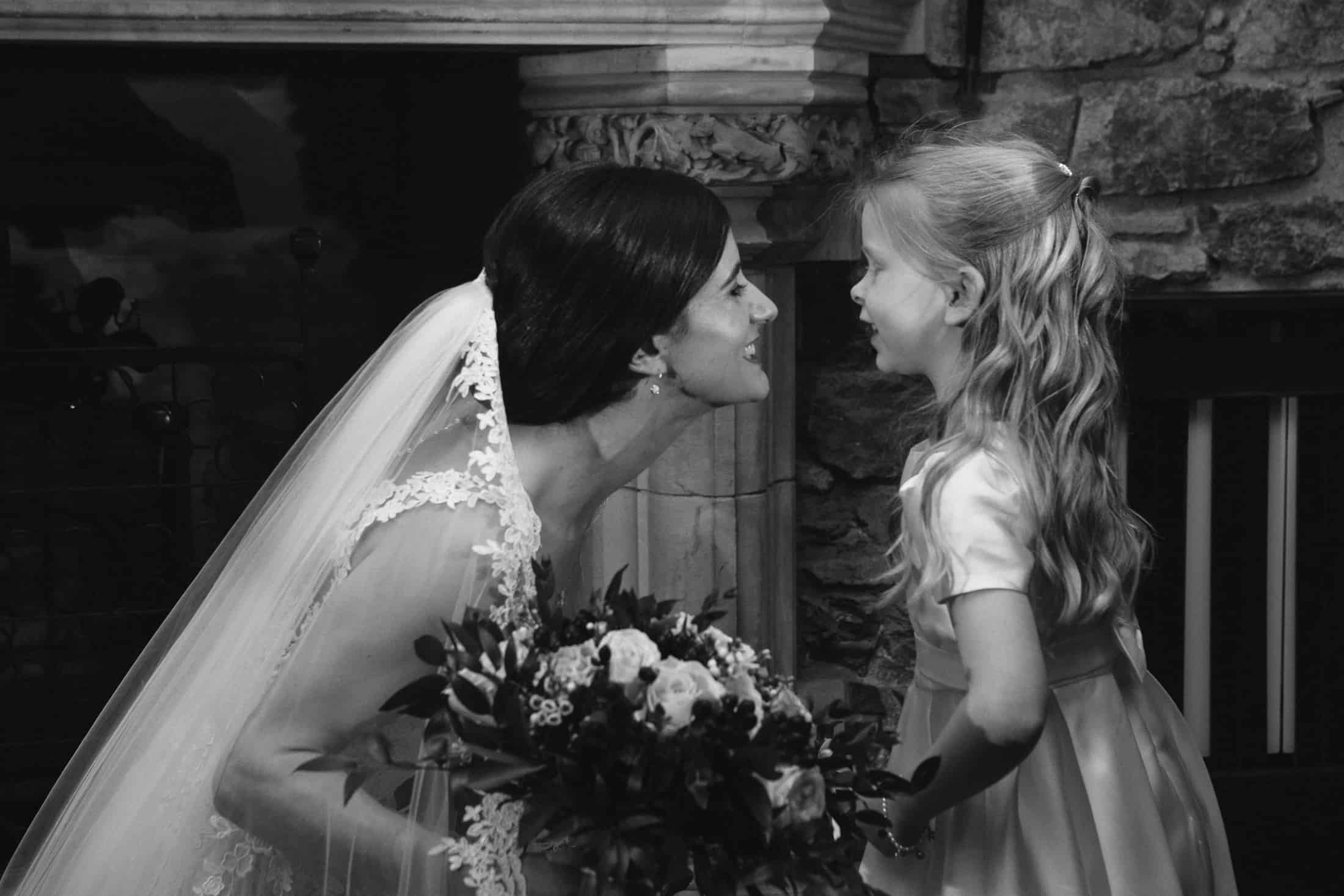 Black and white image bride and flower girl wedding ceremony Eilean Donan Castle