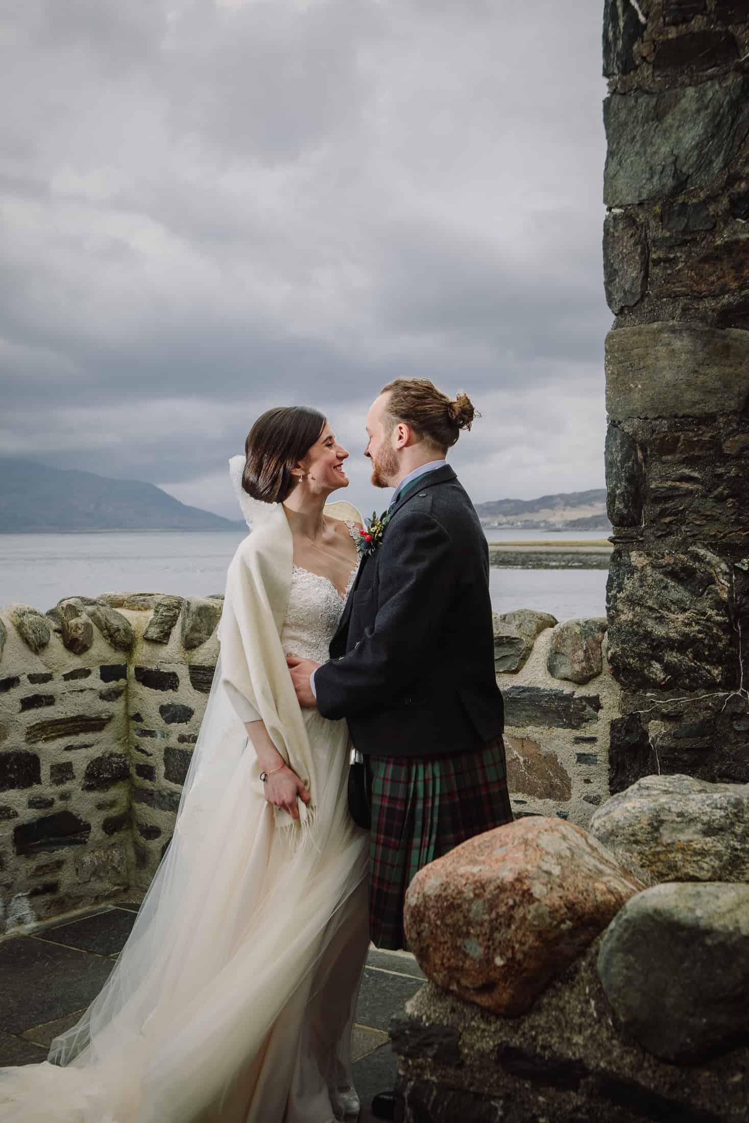 Bride and groom kiss courtyard Eilean Donan Castle wedding photography